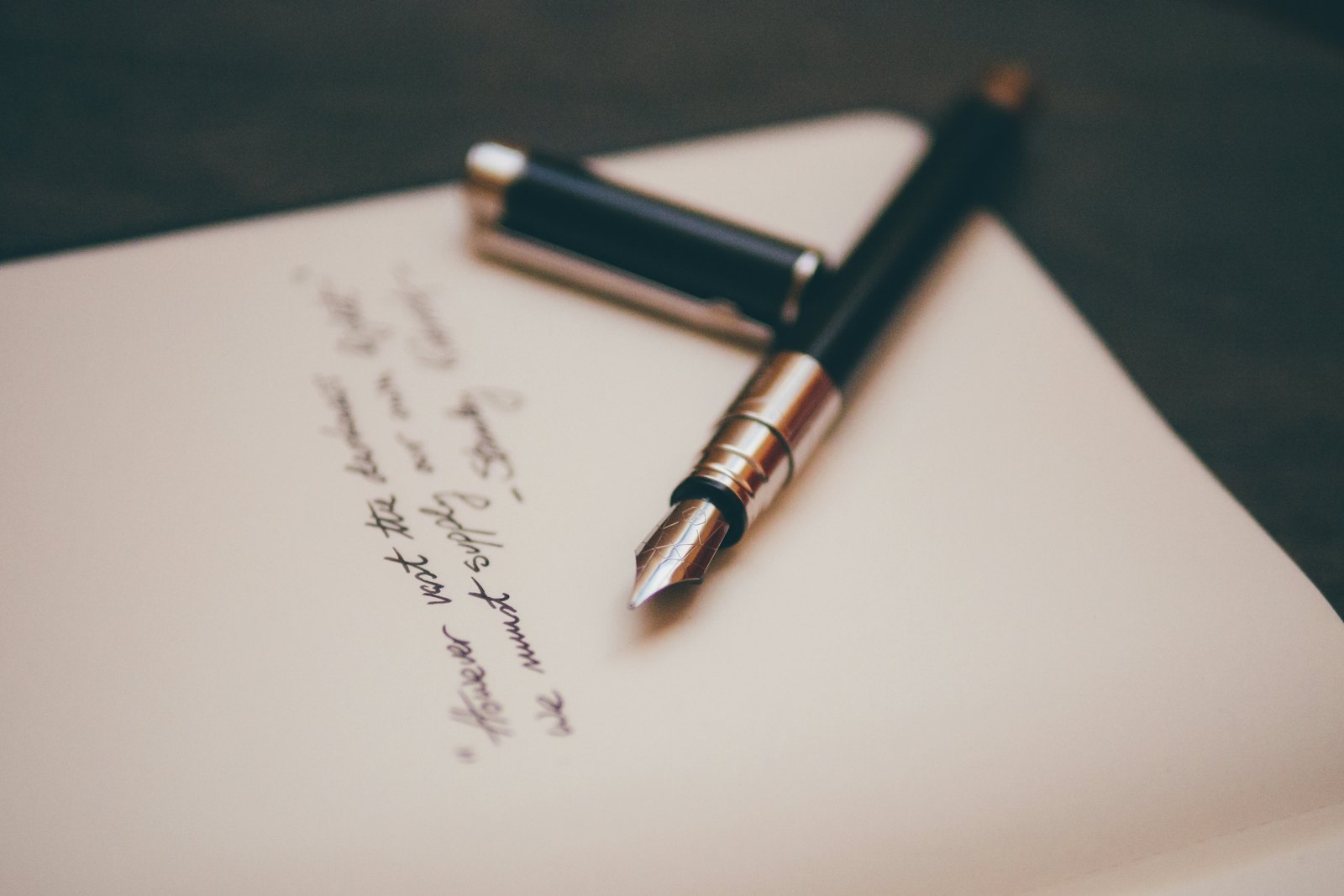 A fountain pen resting on a handwritten document